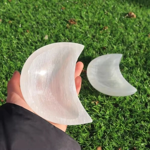Polished crescent-shaped white selenite bowls shown in natural outdoor light for decoration