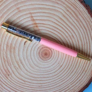 Detail of pink crystal ballpoint pen with gold clips and grey gemstone fillings