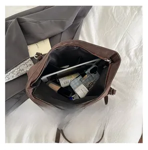 Top view of spacious interior of brown tote bag with tablet, phone and cosmetics
