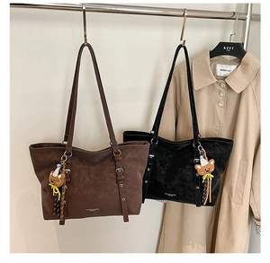 Detail of vintage tote bags in brown and black leather with cute teddy bear pendants
