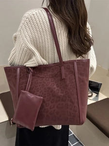 Burgundy leopard print tote bag with small zipper pouch shown on model in modern interior