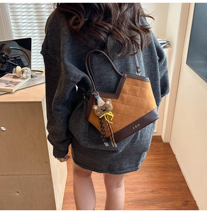Bruine gewatteerde bucket bag met JBH metalen logo en beer hanger in huiselijke sfeer