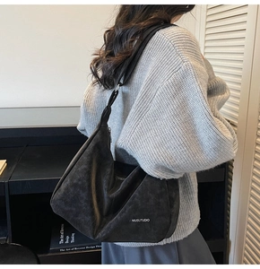 Detailed view of black oversized hobo bag showing soft texture and silver lettering