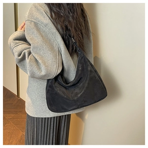 Detail of black suede hobo shoulder bag with matte texture and adjustable strap