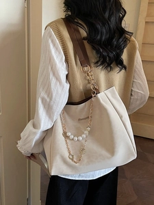 Chic off-white tote bag with brown straps, pearl charms, and gold hardware detail