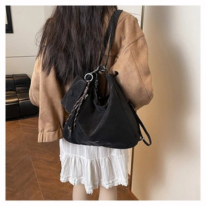 Modell mit schwarzer Hobo-Tasche aus mattem Leder mit Quaste und kleiner Tasche