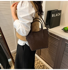 Brown frosted bucket bag worn by model in a stylish side-view with a white shirt