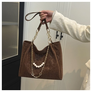 Detail of leopard print tote bag with gold chain strap and pearl floral charm embellishment