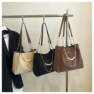 Close-up of textured leopard print tote bags with gold chains and pearl accents