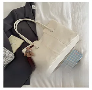 Détail d'un sac cabas en similicuir crème avec texture plissée et charmant lapin en peluche