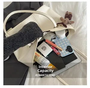 Détail intérieur d'un grand sac cabas crème montrant sa capacité pour tablettes et cosmétiques