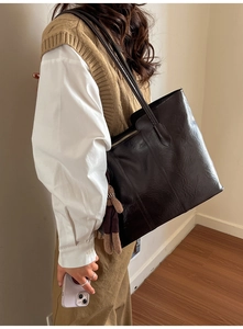 Vue détaillée du grand sac cabas noir en cuir texturé avec un pendentif ours mignon