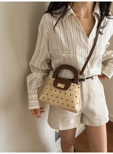 Close-up of retro polka dot handbag with metal twist lock and leather shoulder strap