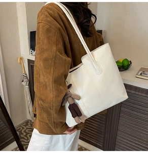 Détail du grand sac cabas en cuir souple blanc cassé avec pendentif ours et bandoulière fine