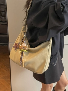 Retro khaki crescent tote bag with cute bear charm shown from a side view on model