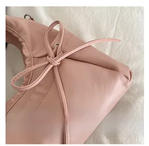 Detailed view of pink pleated bow detail with silver eyelets on a soft PU leather handbag