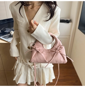 Detailed view of pink bow-knot hobo bag in nylon fabric with delicate shoulder strap