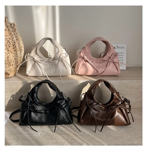 Minimalist crescent handbags with bow details in four colors on stone display
