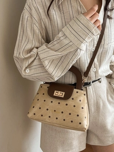 Vintage beige polka dot handbag with brown leather trim and golden twist lock closure