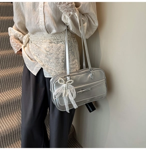 Silver metallic shoulder bag with pearl lace bow charm and decorative ribbon detail