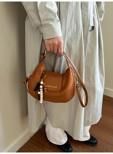 Dettaglio della borsa hobo marrone con finitura opaca e accessorio con perline vintage