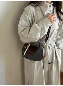 Detail of vintage suede moon bag in dark grey and brown leather with beaded tassel