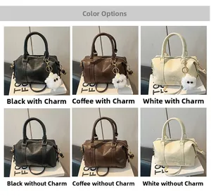 Detail view of mini Boston bag showing pebble leather texture and sturdy top handles