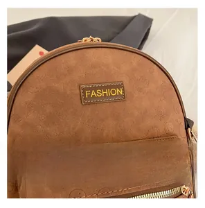 Gros plan sur un sac à dos en daim marron avec embossage cartoon et étiquette mode