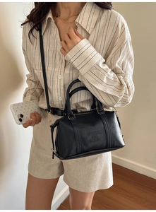 Detail of black Boston bag with Fashion Air Paris engraving and gold hardware