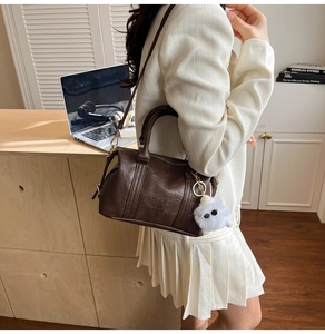 Detail view of brown vintage Boston bag with Fashion in Paris embossing and plush charm