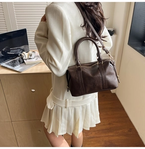 Detail of dark brown Boston bag with Fashion Airs Paris embossing and pleated texture