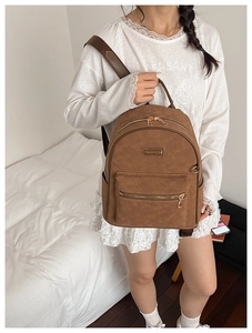 Vue détaillée du sac à dos vintage marron avec texture gaufrée et étiquette en métal