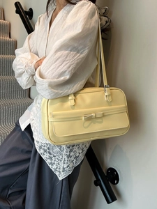 Pale yellow leather underarm Boston bag with bow accent and slim double shoulder straps