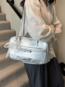 Silver metallic shoulder bag with bow detail and pearl lace charm on white shirt model