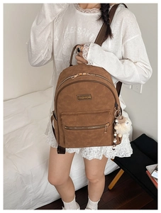 Détail du sac à dos vintage marron avec motifs gaufrés et pendentif mouton doux
