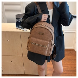 Détail d'un sac à dos vintage marron avec étiquette FASHION et motif gaufré