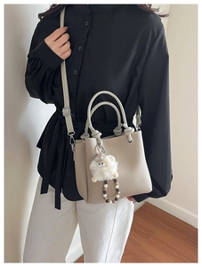 Chic beige tote bag with soft sheep plush charm and grainy PU leather texture details