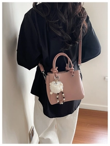 Pink tote bag detail with lychee texture leather, faux fur pom and bead chain charm