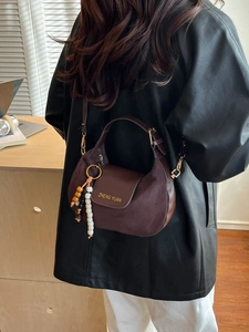 Minimalist coffee brown crescent shoulder bag with vintage suede finish and bead charm