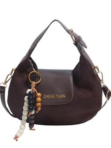 Minimalist brown half-moon crossbody bag in suede leather with decorative metal ring