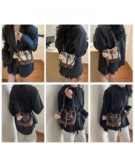Detail view of canvas bucket bag with plush bear charm and adjustable shoulder straps
