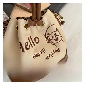 Close-up of the bucket bag with drawstring closure and fine cartoon embroidery details