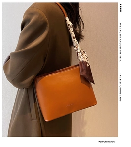 Gros plan du sac à bandoulière caramel avec foulard en soie à imprimé léopard
