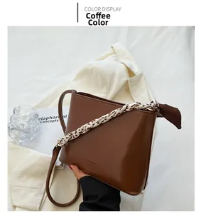 Détail du sac seau en cuir marron café avec anse en foulard et logo en relief