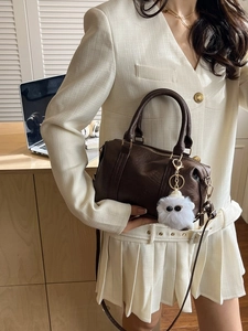 Classic dark brown leather Boston bag with plush charm and adjustable shoulder strap