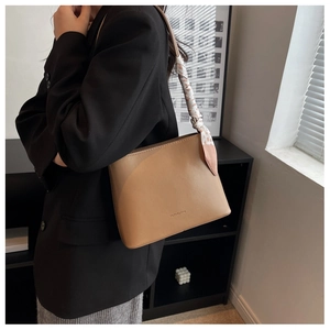 Détail du sac cabas camel avec foulard en soie sur la bandoulière et logo imprimé
