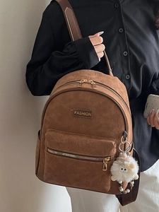 Sac à dos vintage en cuir marron avec motifs gaufrés et breloque en peluche sur mannequin