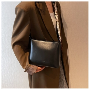 Sac bandoulière minimaliste en cuir noir avec foulard léopard porté par un mannequin