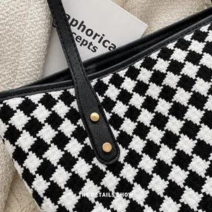 Detailansicht der Hahnentritt-Tasche mit Lederbesatz und goldenen Nietennähten