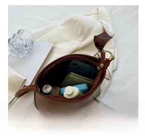 Vue intérieure montrant la grande capacité d'un sac à bandoulière en cuir marron garni